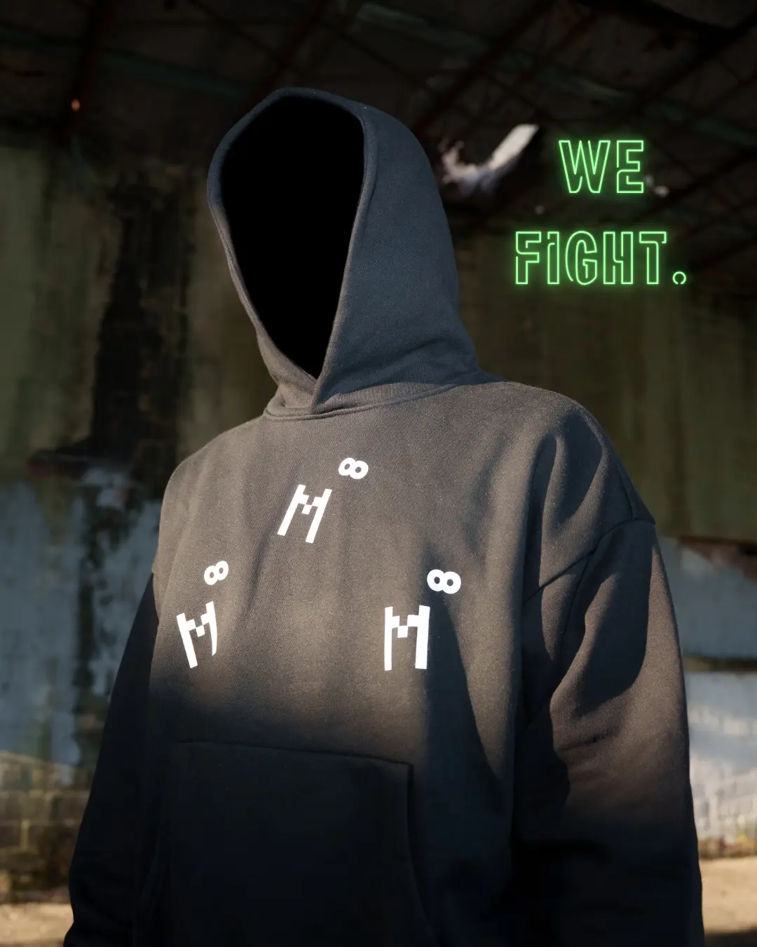 WE FIGHT — hooded figure with reflective M infinity marks